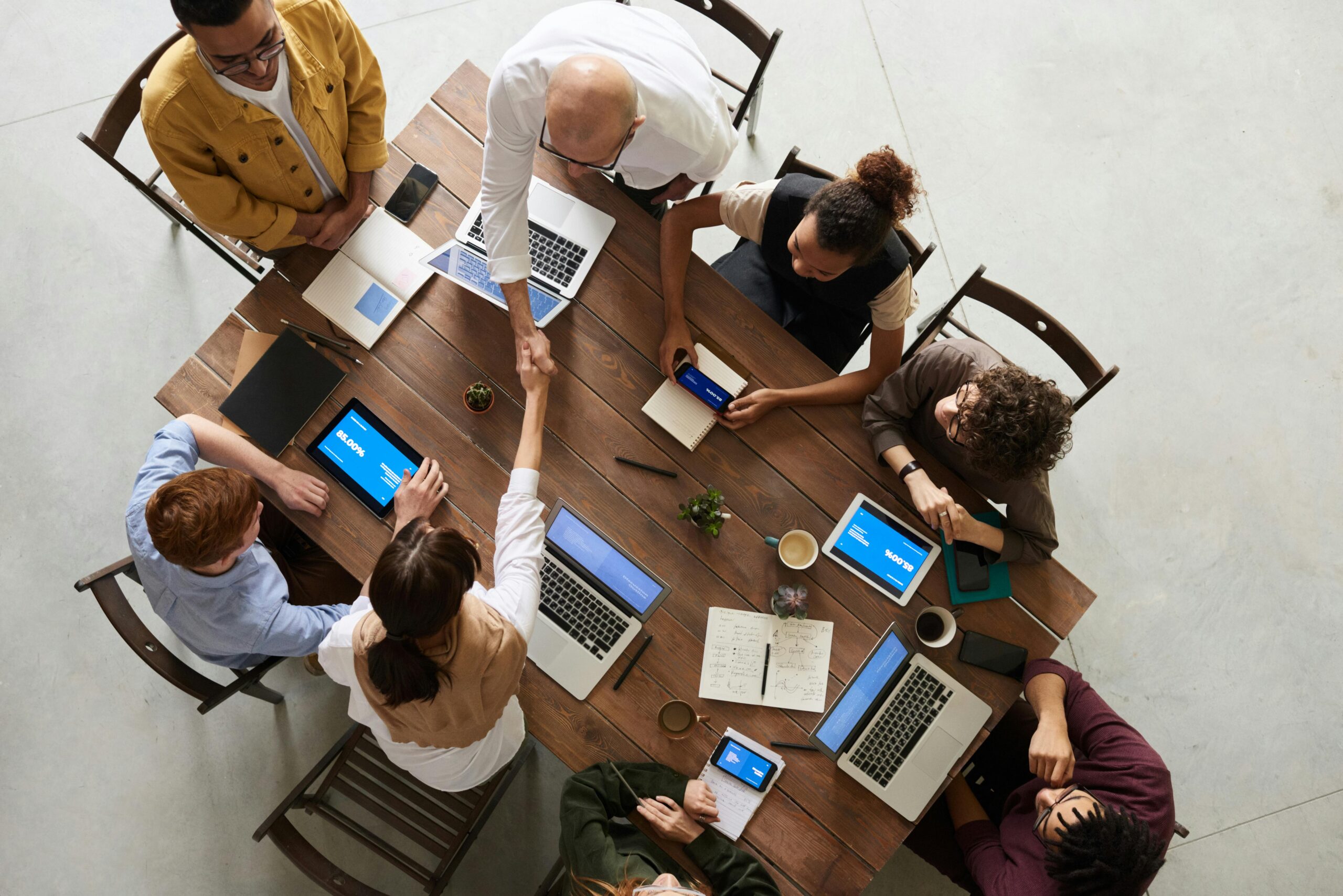 Office workers gather around a table and work collaboratively.